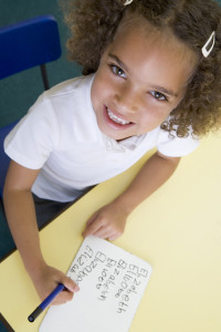 Girl learning to write name in primary class